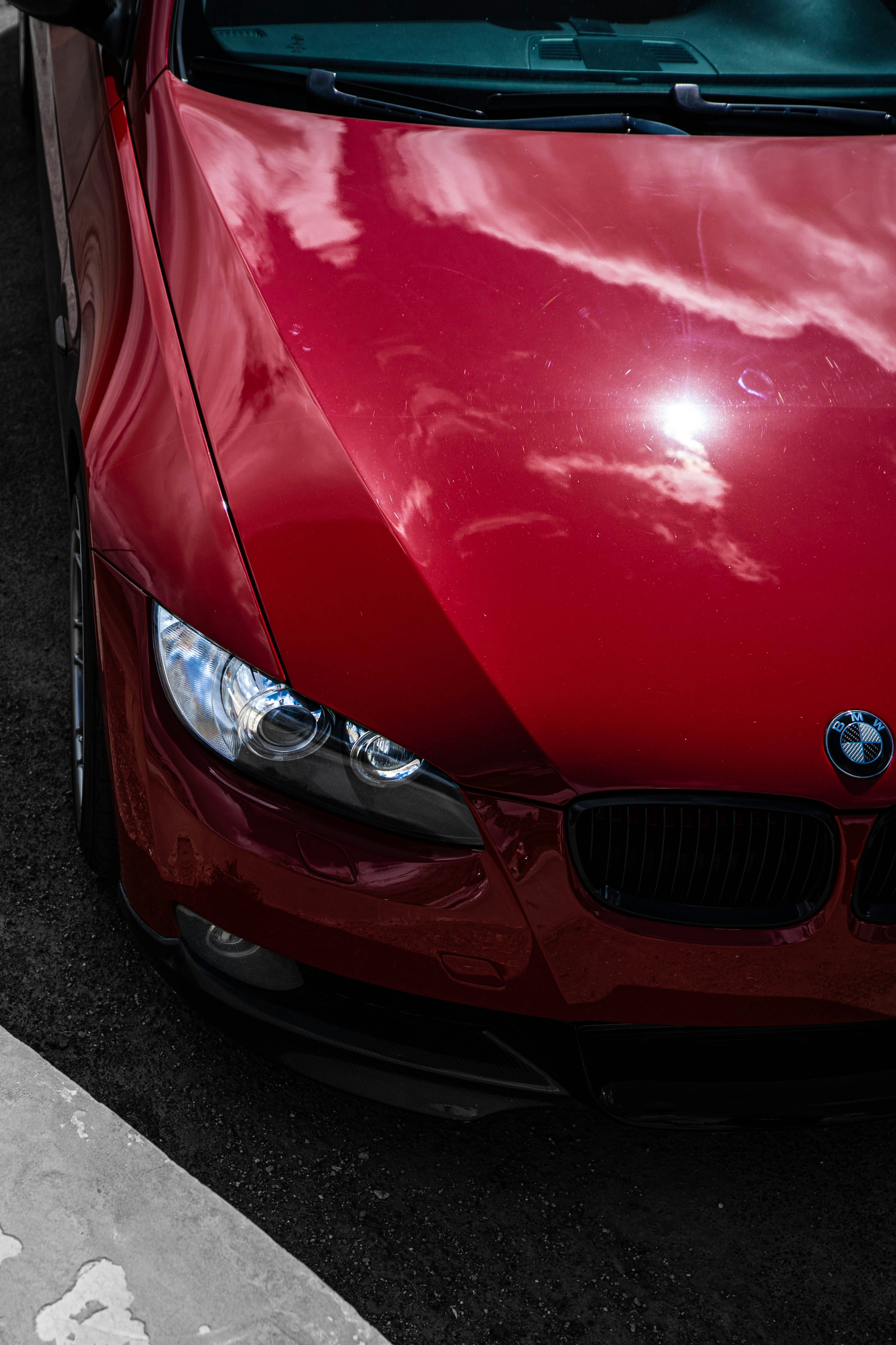A shiny red BMW reflects the sky.