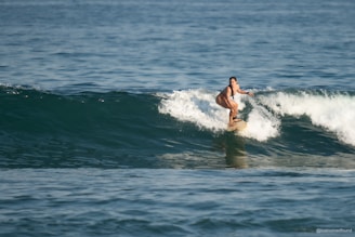 A woman surfs a wave in the ocean.