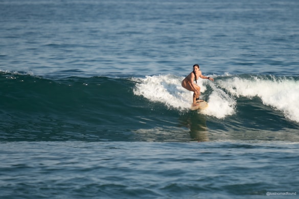 A woman surfs a wave in the ocean.