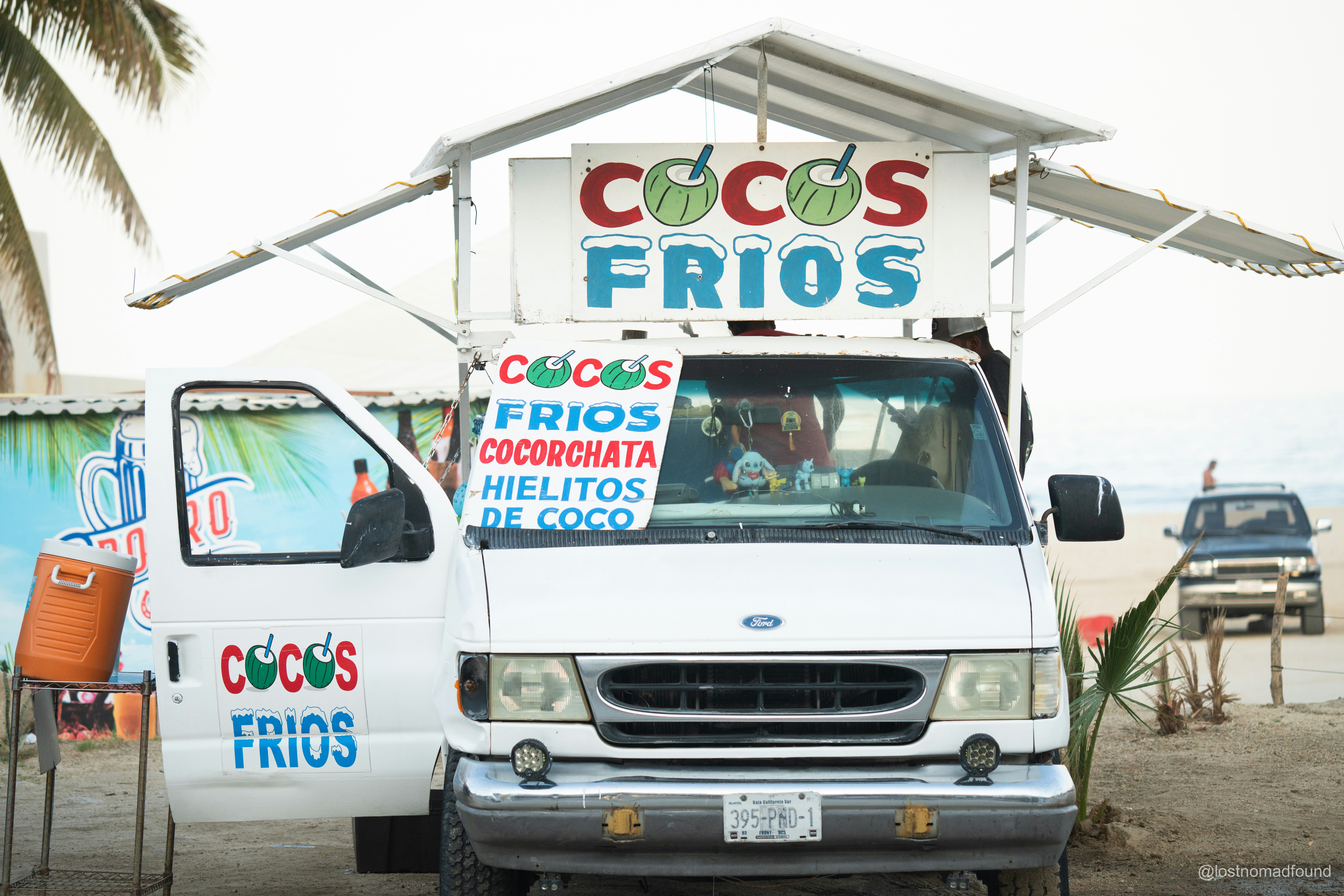 A van sells cold coconuts and coconut treats.