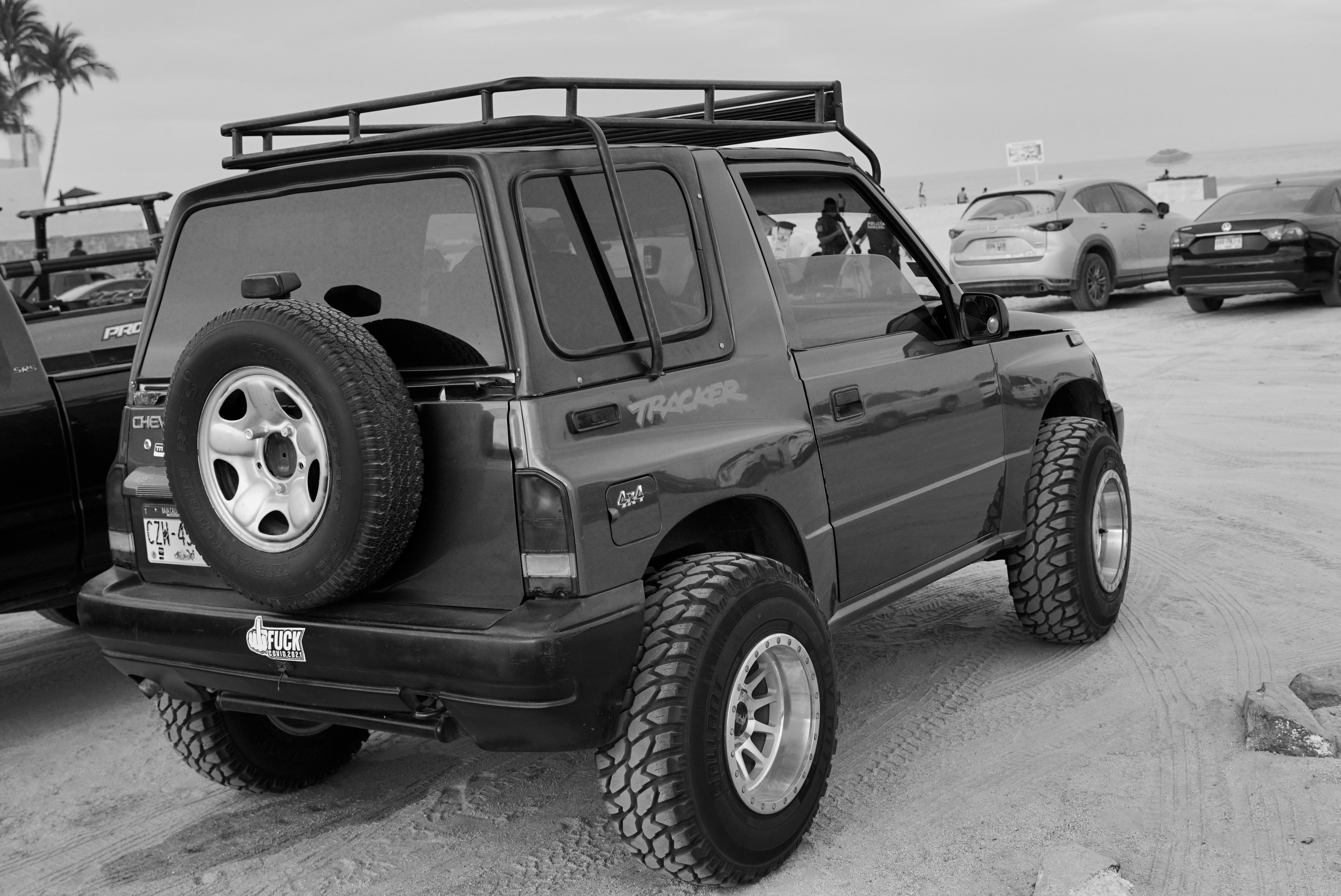 A black suv is parked at a beach.