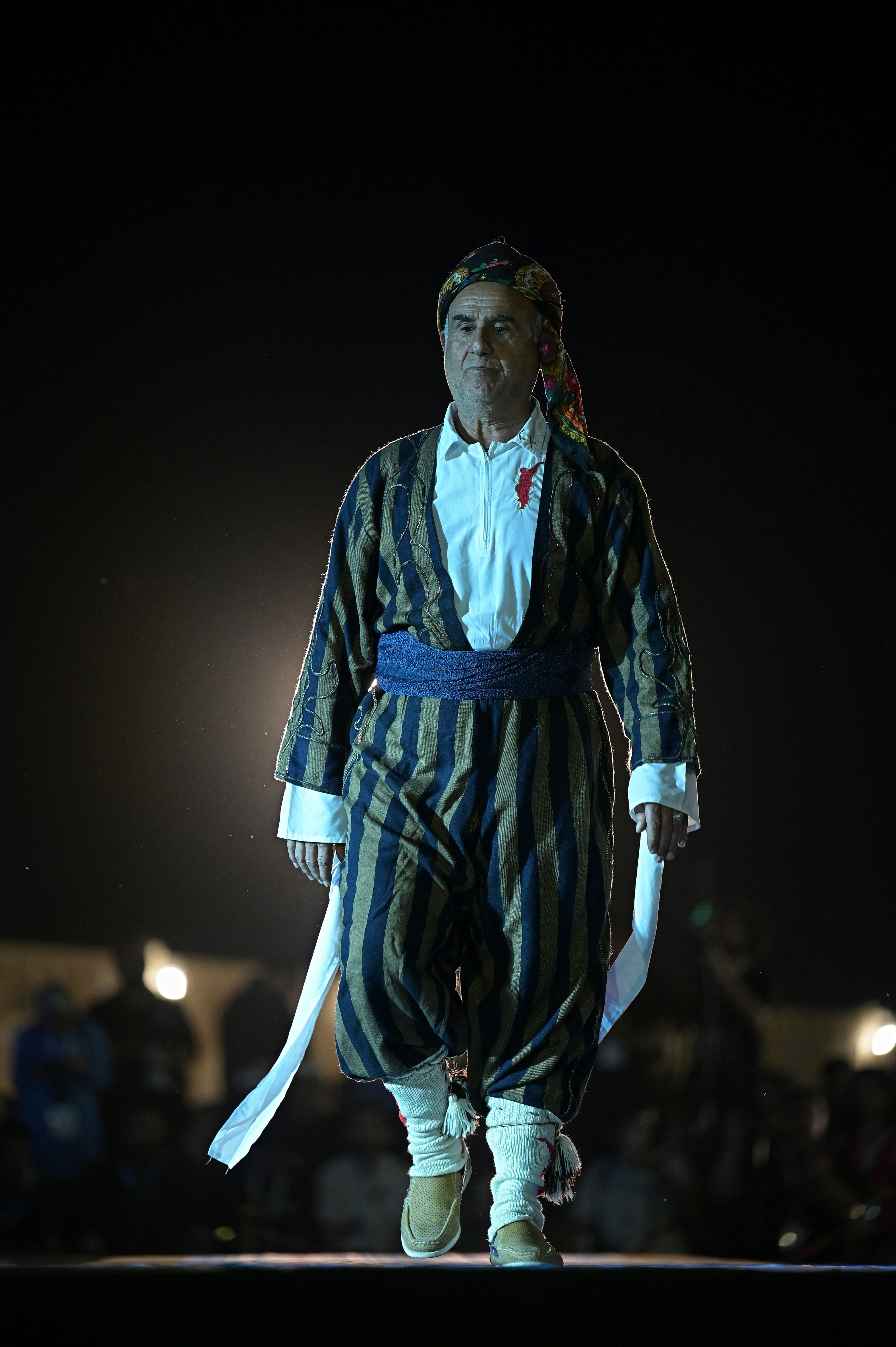 Un uomo cammina in costume tradizionale.