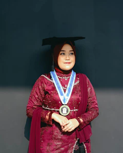 A woman poses in her graduation attire.