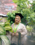 A graduate poses in her cap and gown.