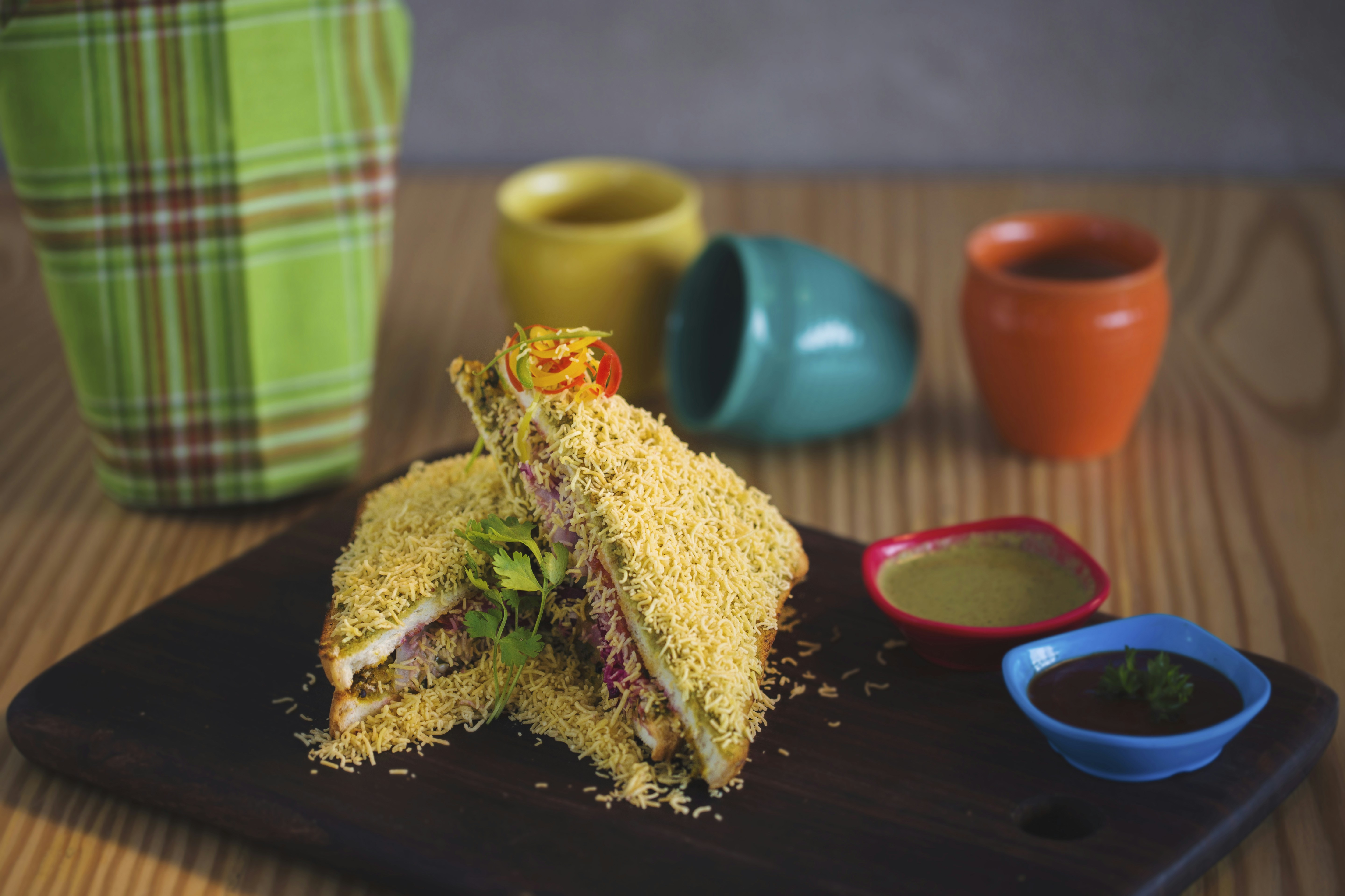 Delizioso panino con salse colorate e tazze.