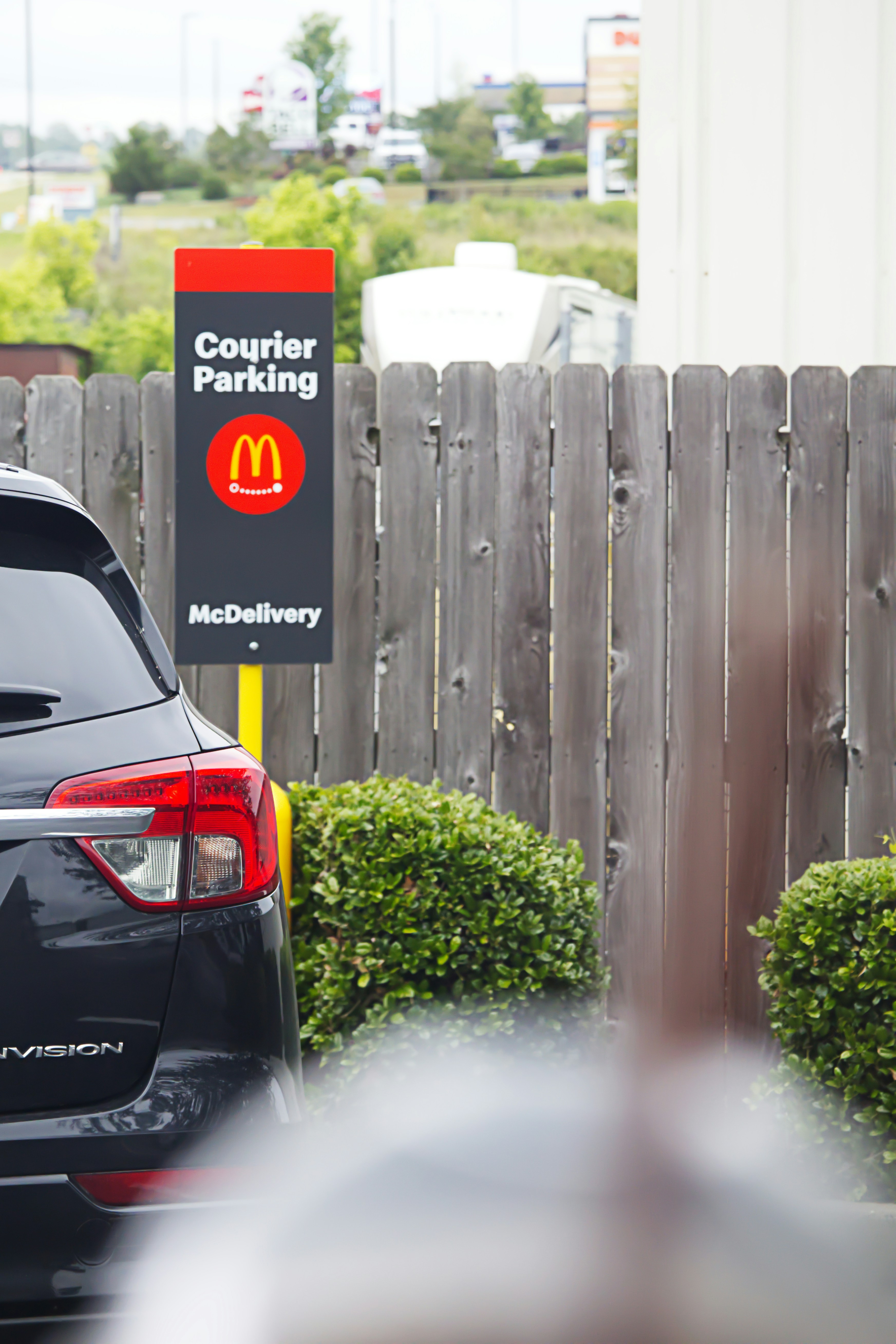 Tanda parkir kurir Mcdonald's di samping mobil.