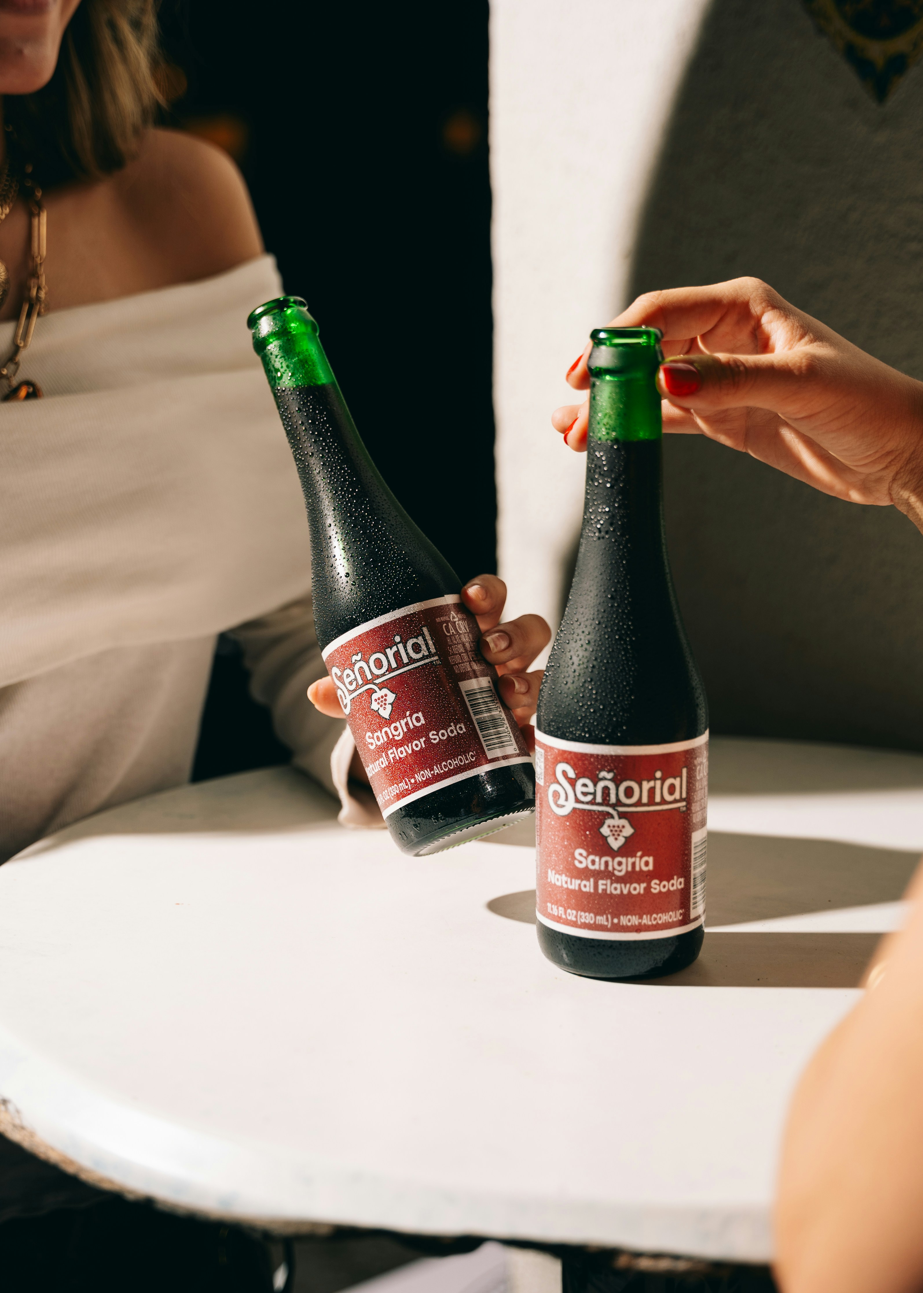 People are holding bottles of señorial sangria.