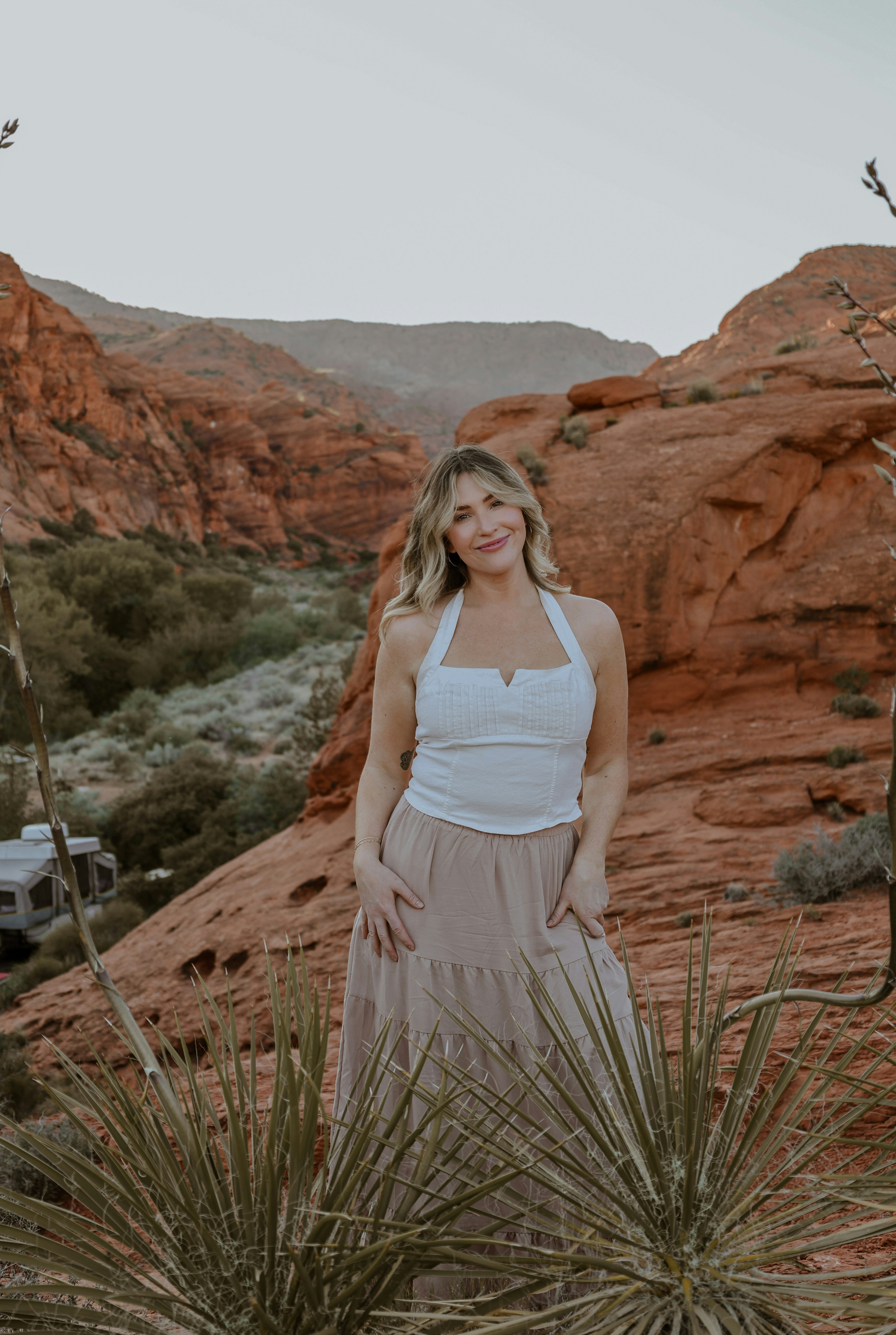 Woman poses in front of a red rock landscape