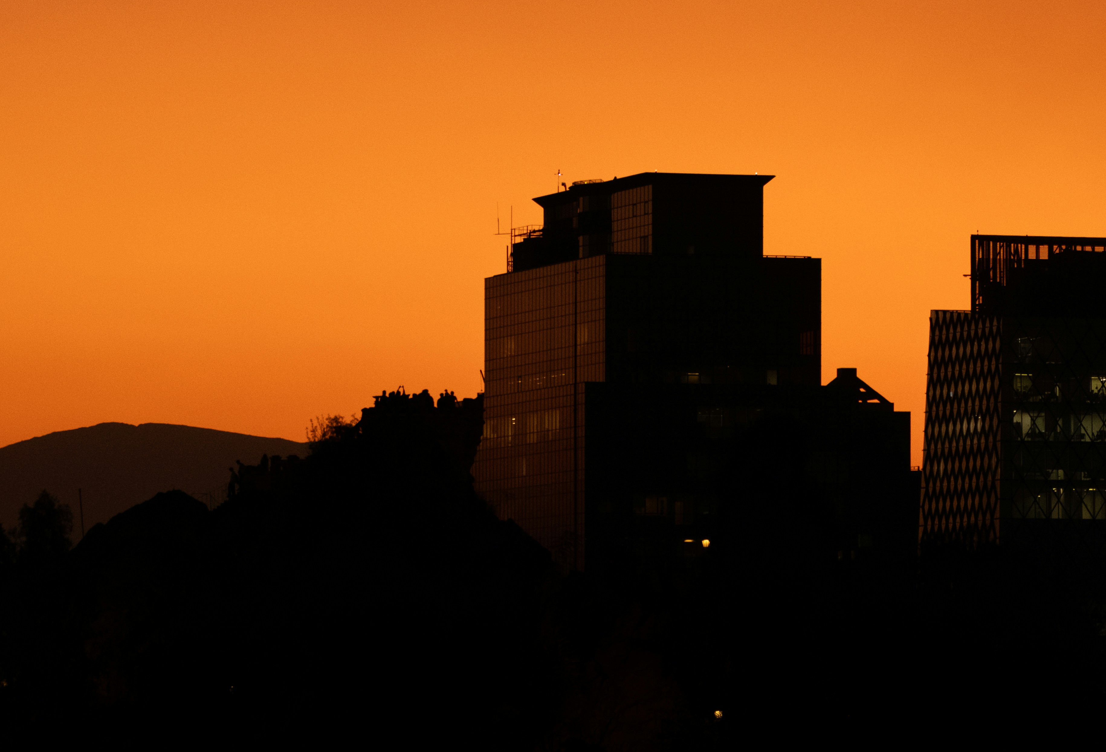 Buildings stand silhouetted against a sunset sky.