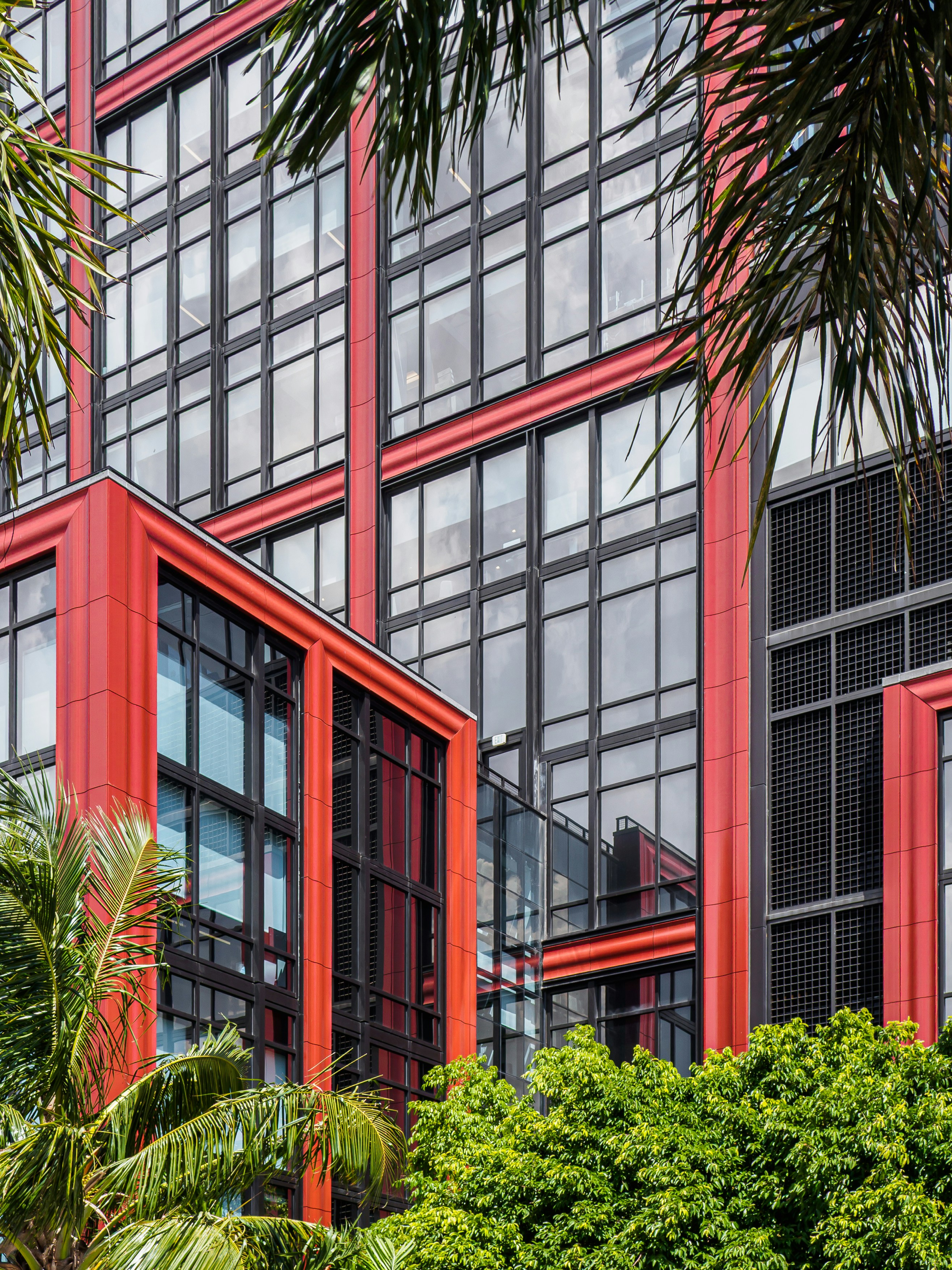 Red-framed skyscraper peeks through the green foliage. photo – Free Usa ...