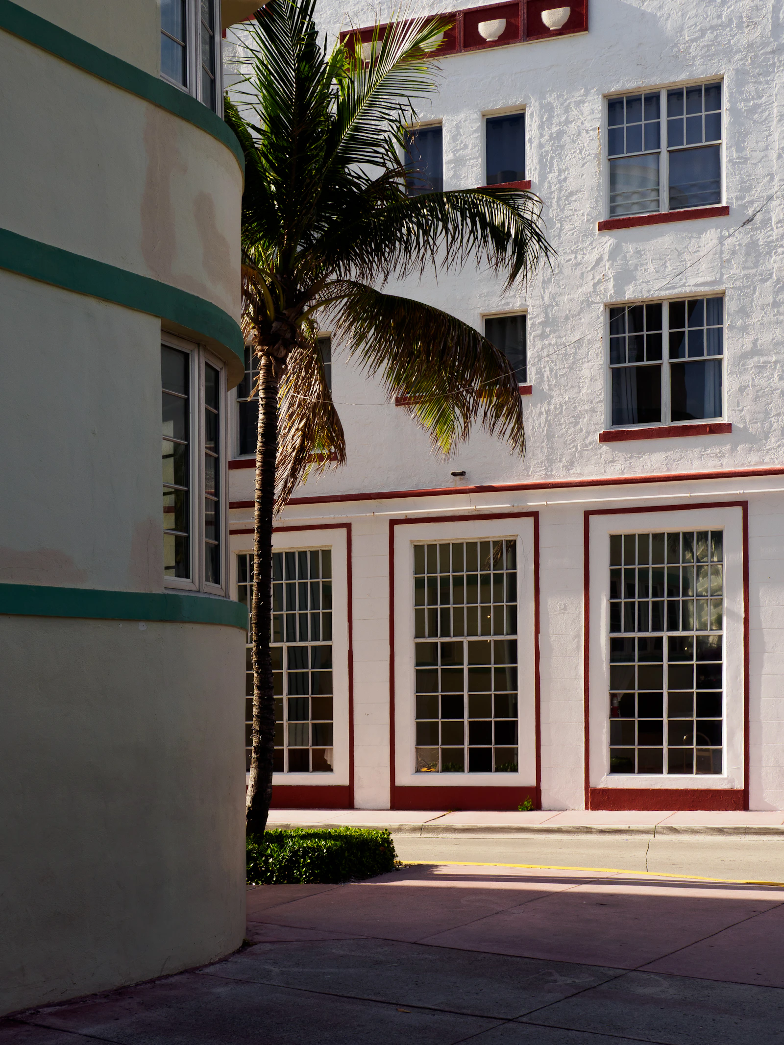 Pastel art deco buildings and palm trees, evoking a Miami-style coastline