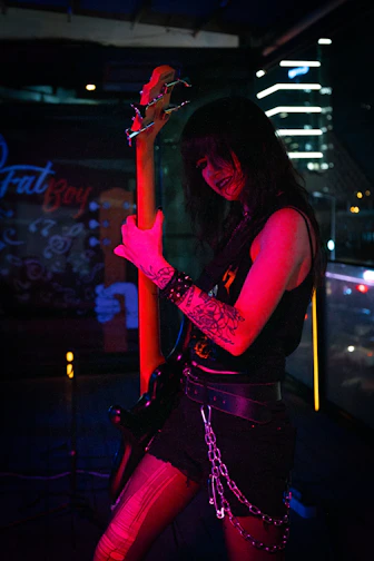 A rocker plays a bass guitar in a dark venue