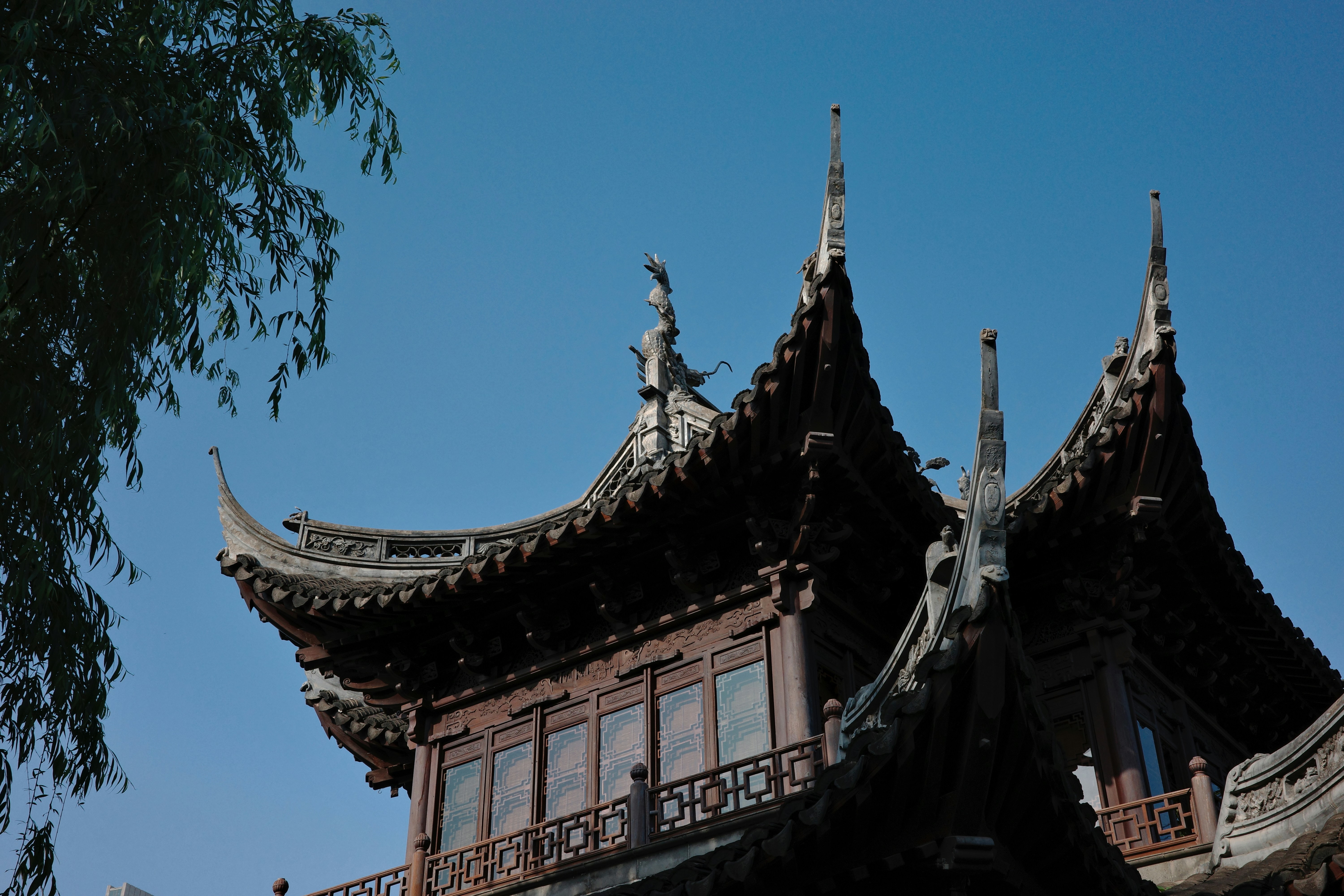 Ornate chinese building against a bright blue sky.