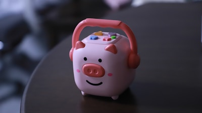 A cute pig-shaped speaker sits on a table.
