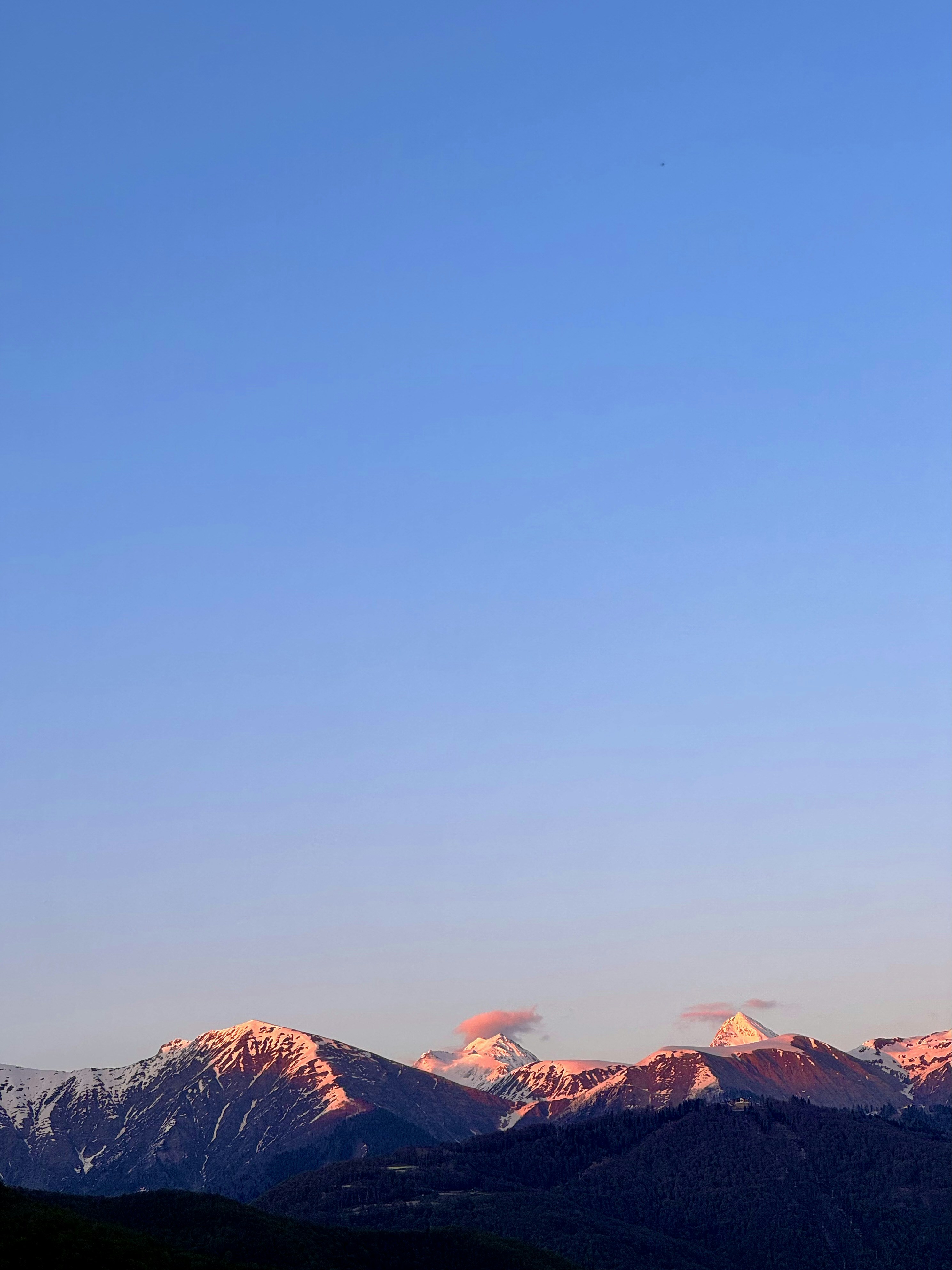 Mountains are illuminated with a soft, pink light.