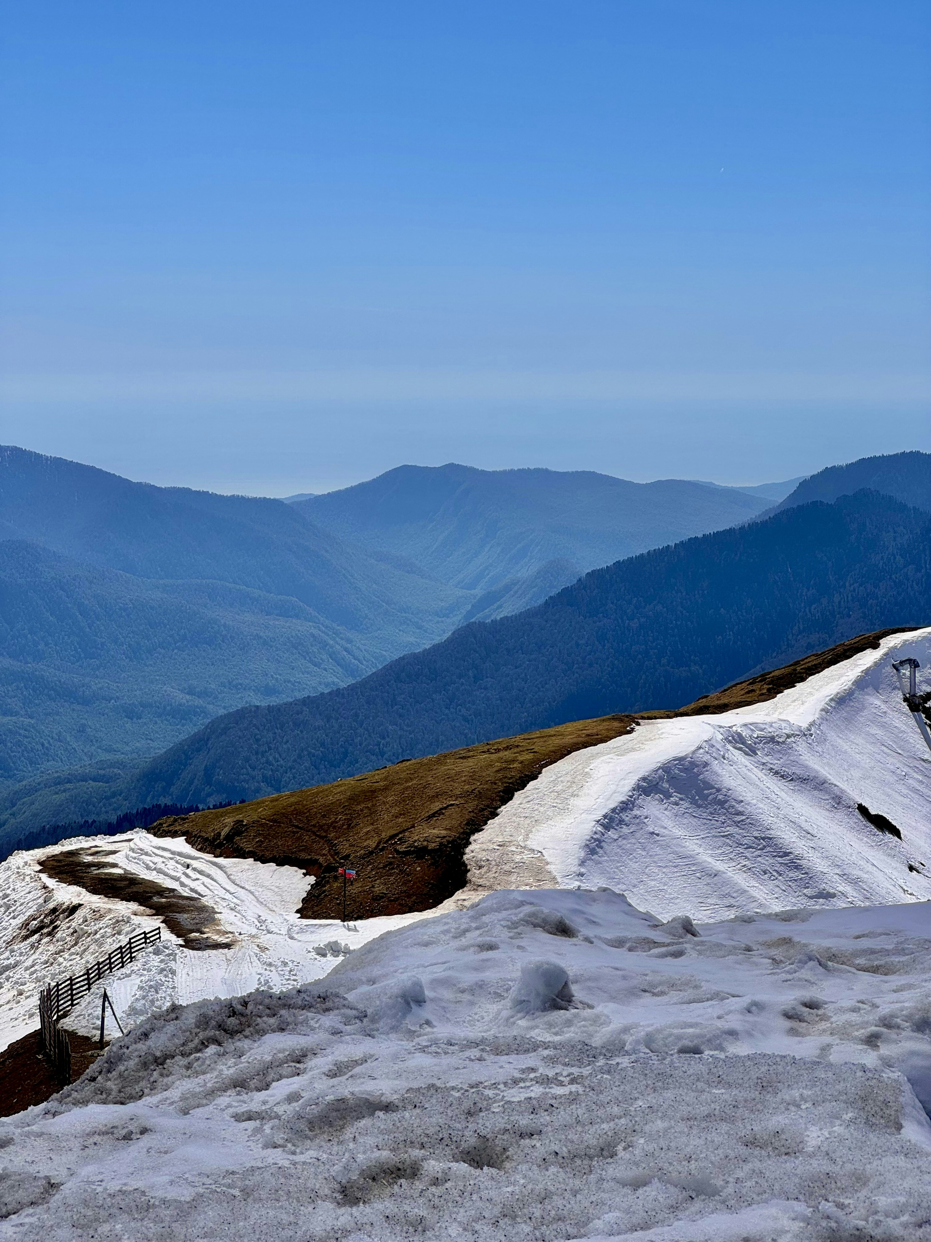 Snowy mountain peaks overlook a distant mountain range.