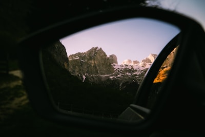 Mountains reflected in a car's side mirror.