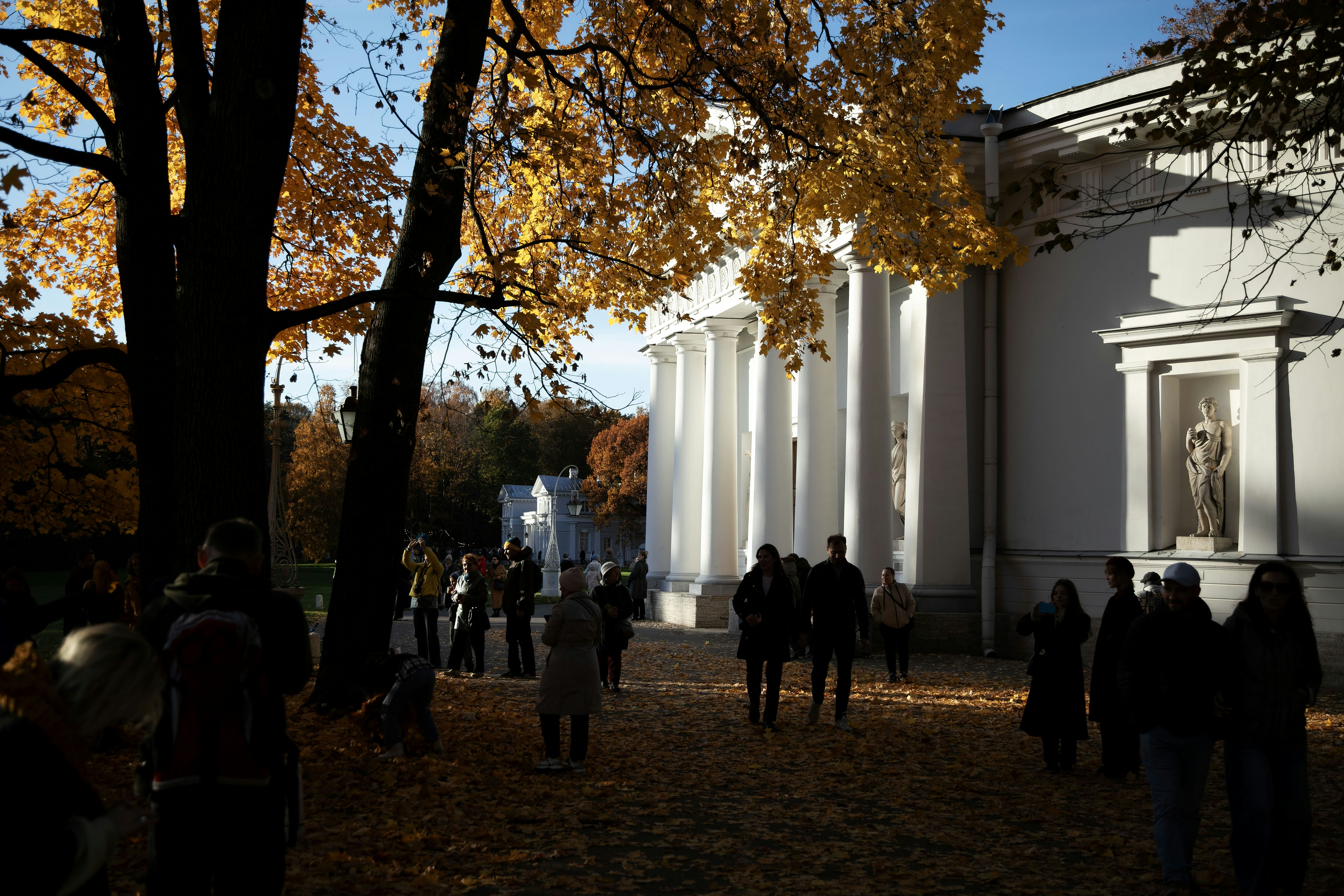 People walk in front of a bright white building