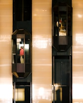 Two elevators are moving up and down a building.