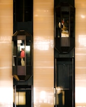 Two elevators are moving up and down a building.