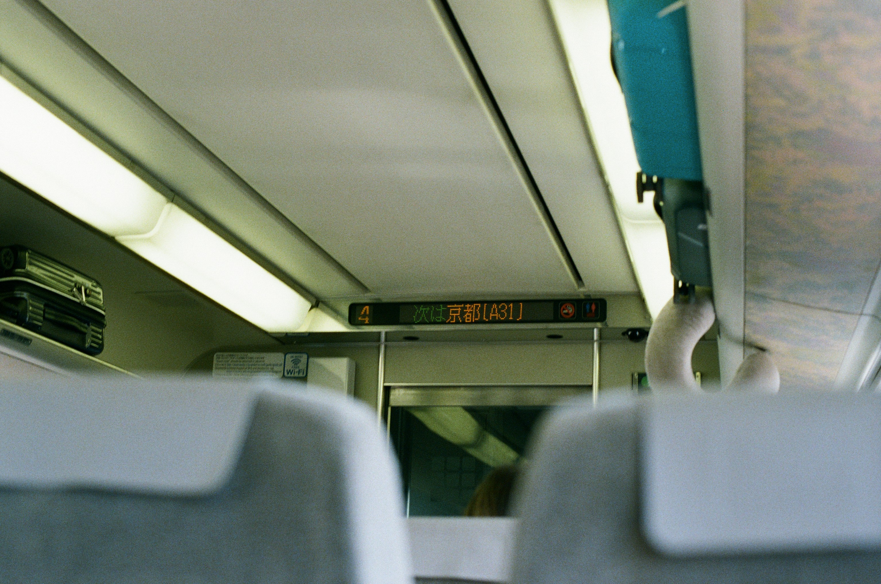 Inside a train car, looking toward the information display.