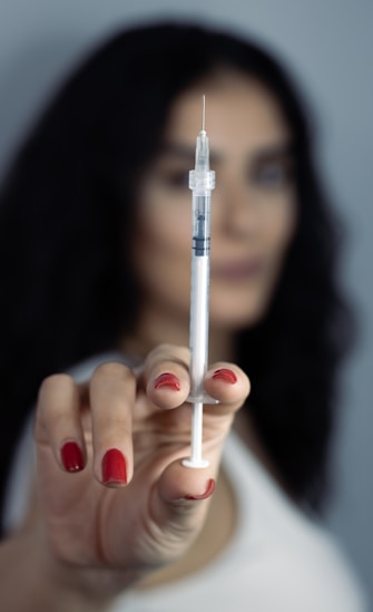 A person is holding up a syringe.