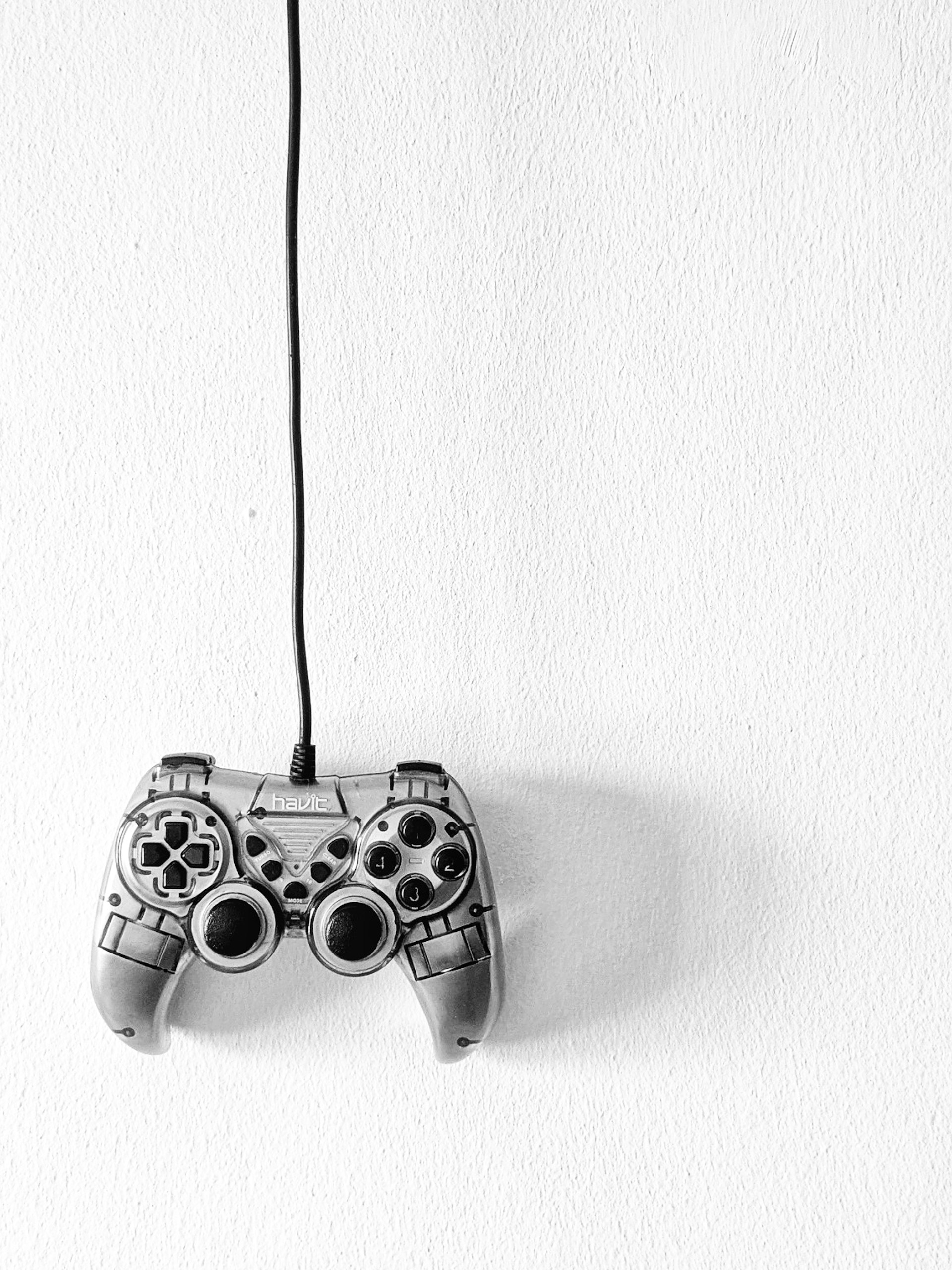 A wired game controller is hanging from above.