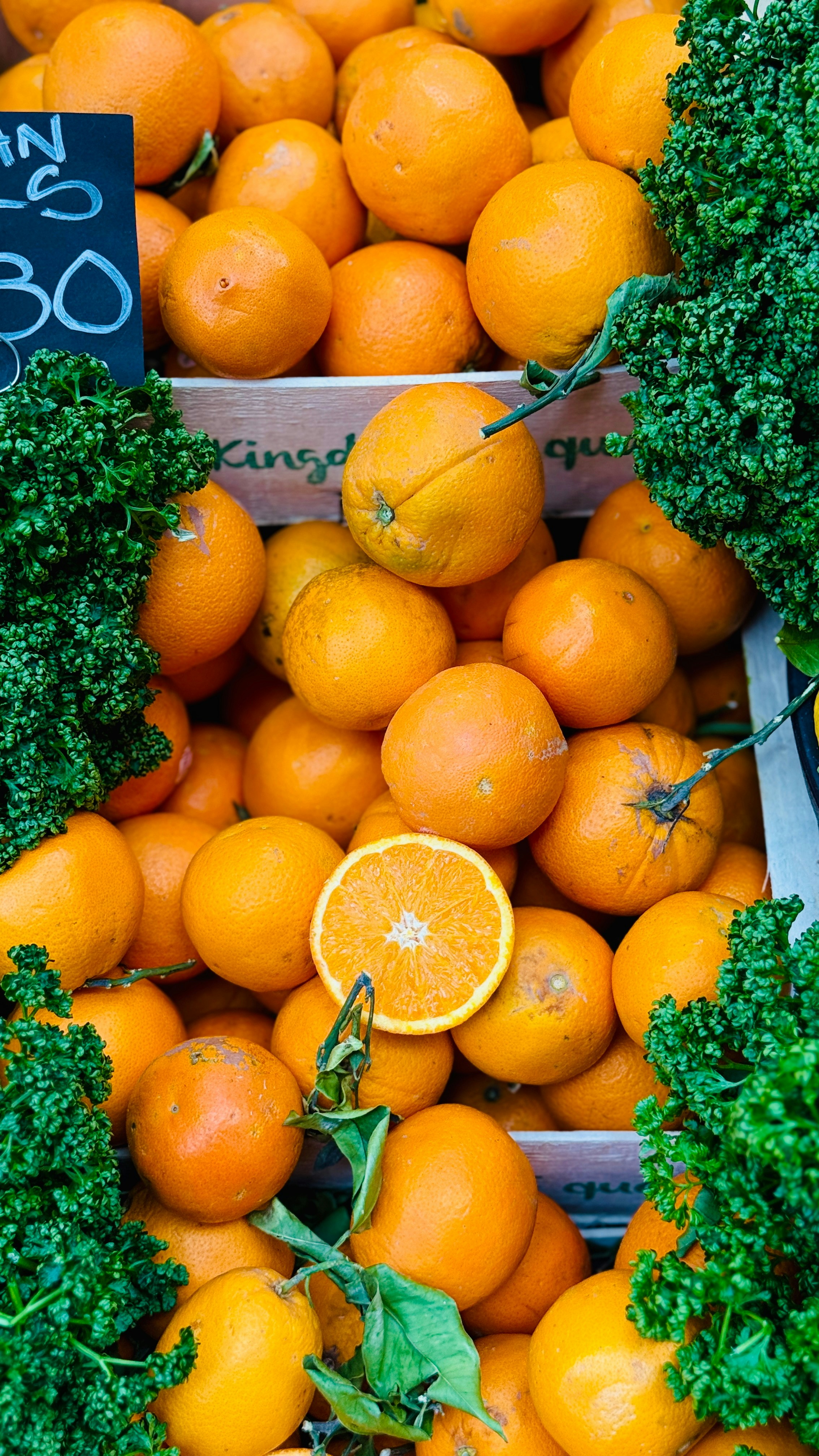Des oranges et des légumes verts frais sont prêts à être vendus.