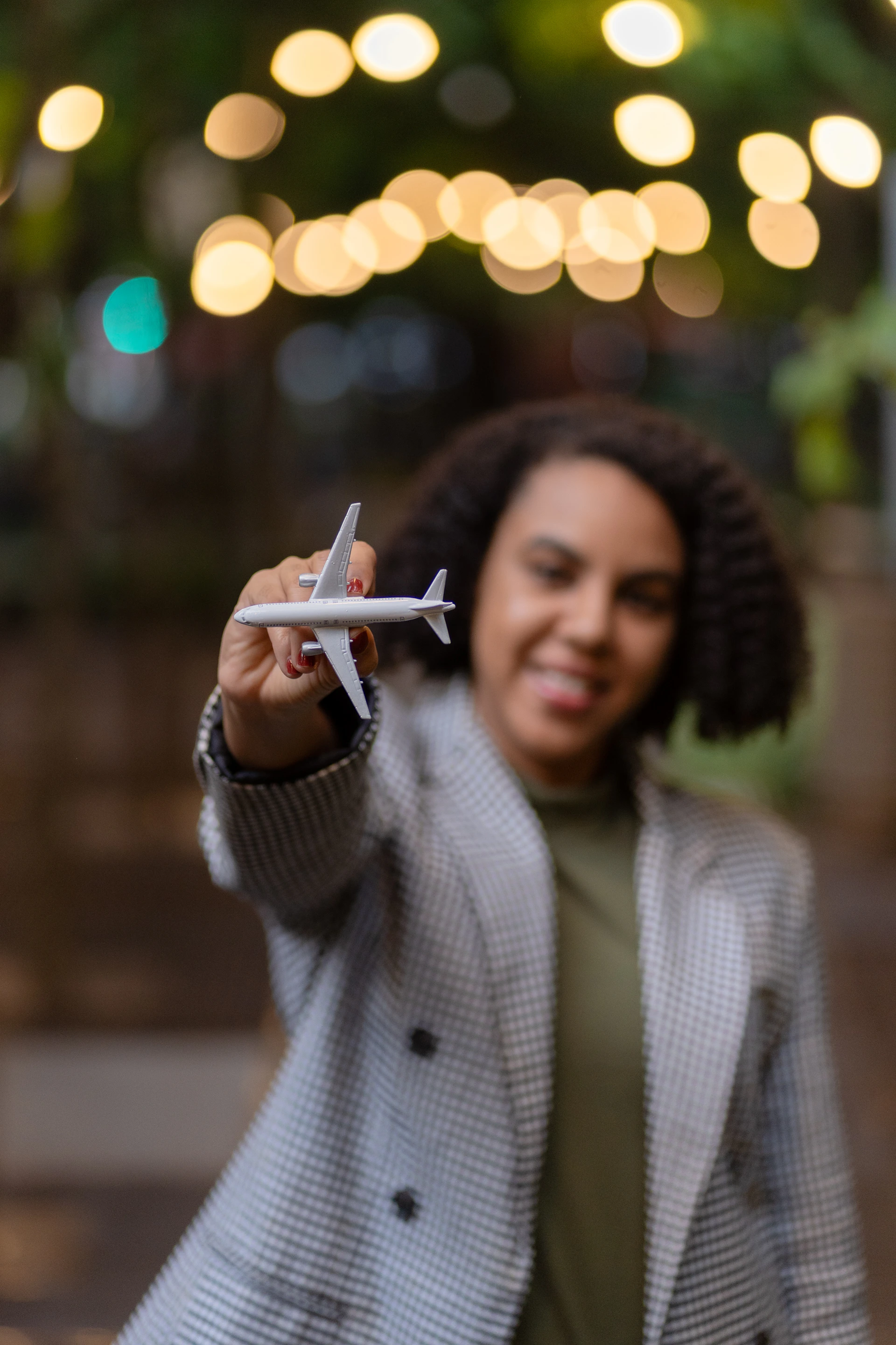 Woman happily holds a toy airplane aloft.