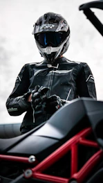 A motorcyclist puts on gloves.
