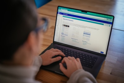 Someone is using a laptop, viewing a webpage.