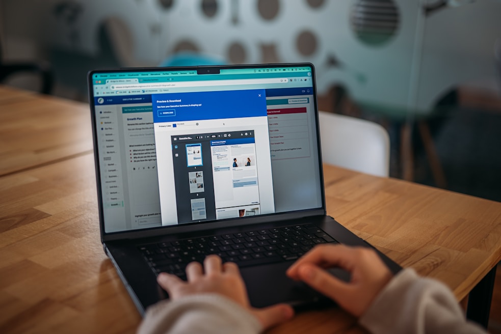 Someone is working on a laptop, viewing a presentation.