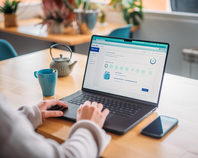 Person works on laptop at a desk with tea.