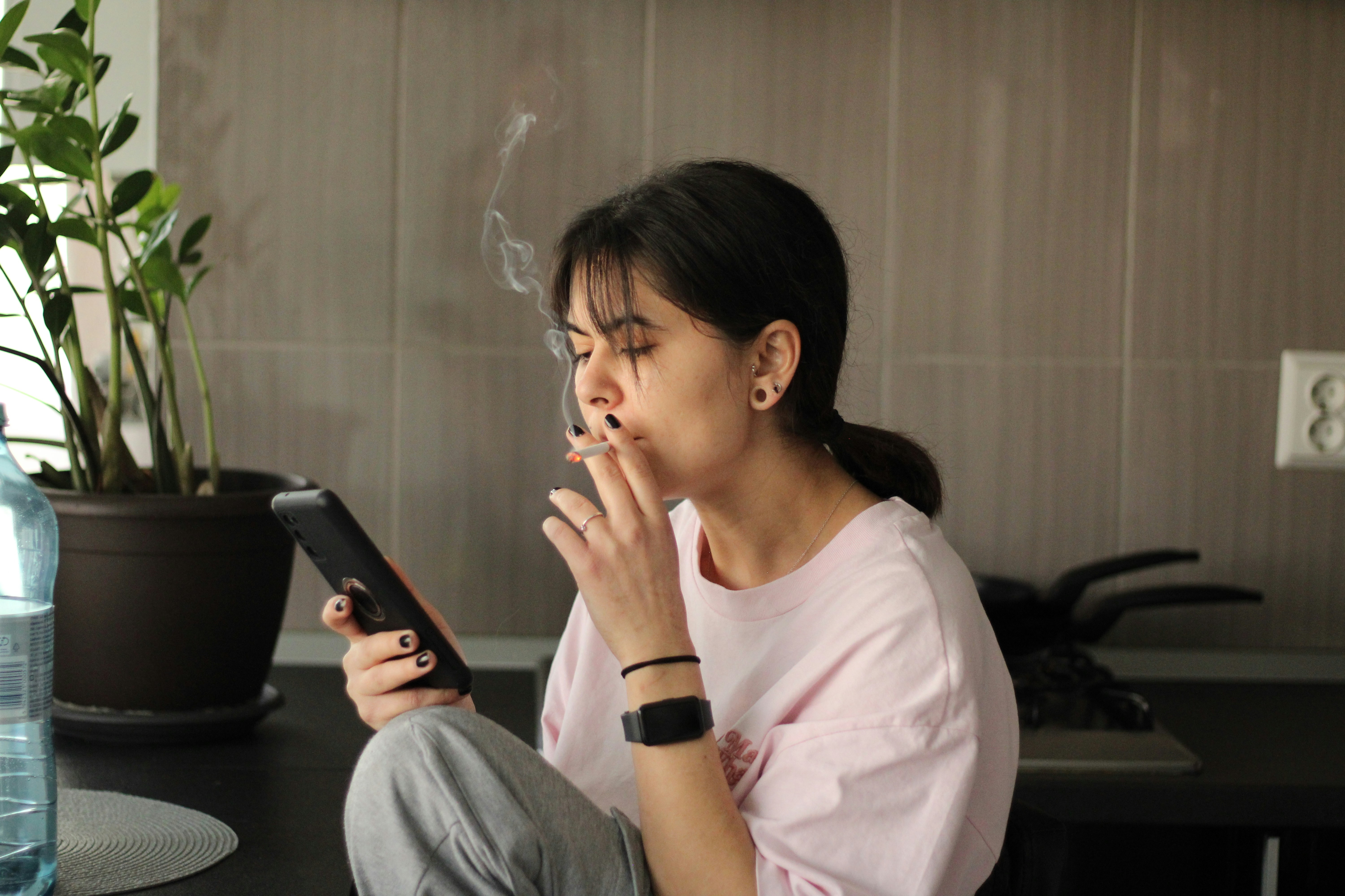 Woman smokes while using her phone