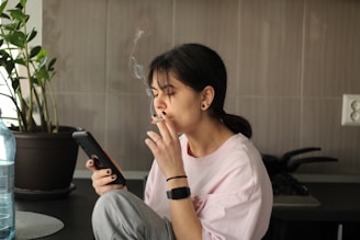 Woman smokes while using her phone.