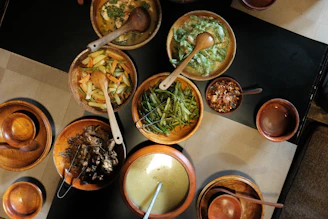 Various dishes of food are served in wooden bowls.