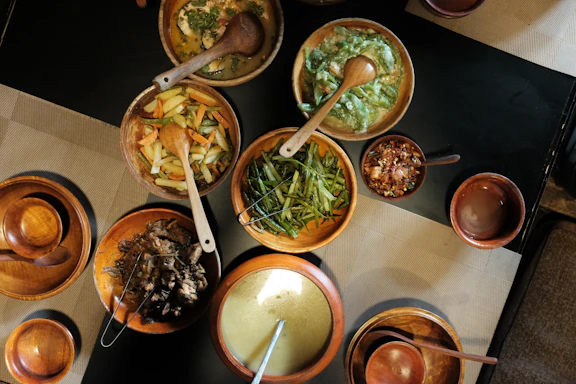 Various dishes of food are served in wooden bowls.