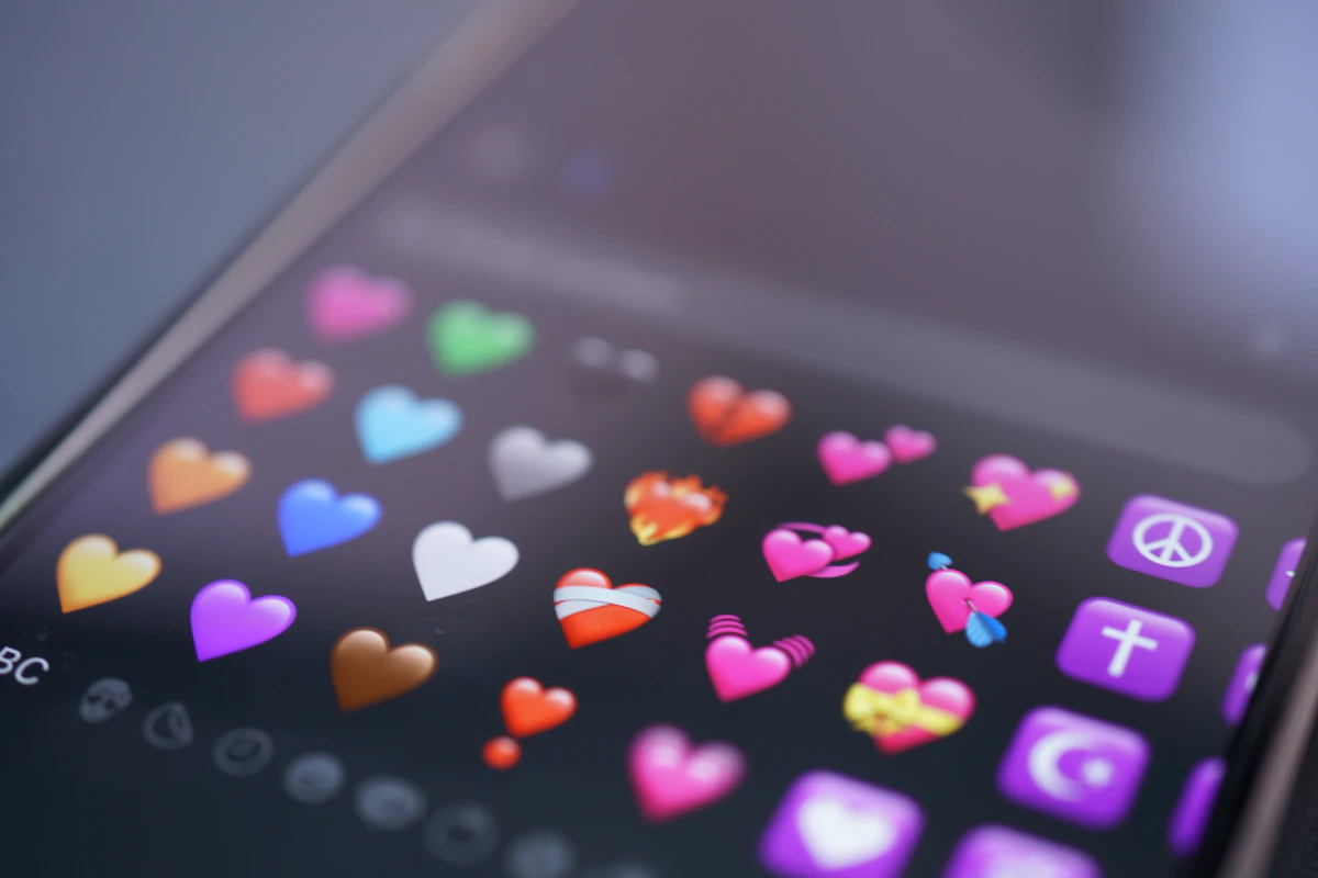 Phone screen showing colorful heart emojis, symbolizing a dating app