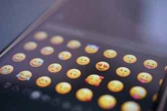 An emoji keyboard is displayed on a phone communication with clients