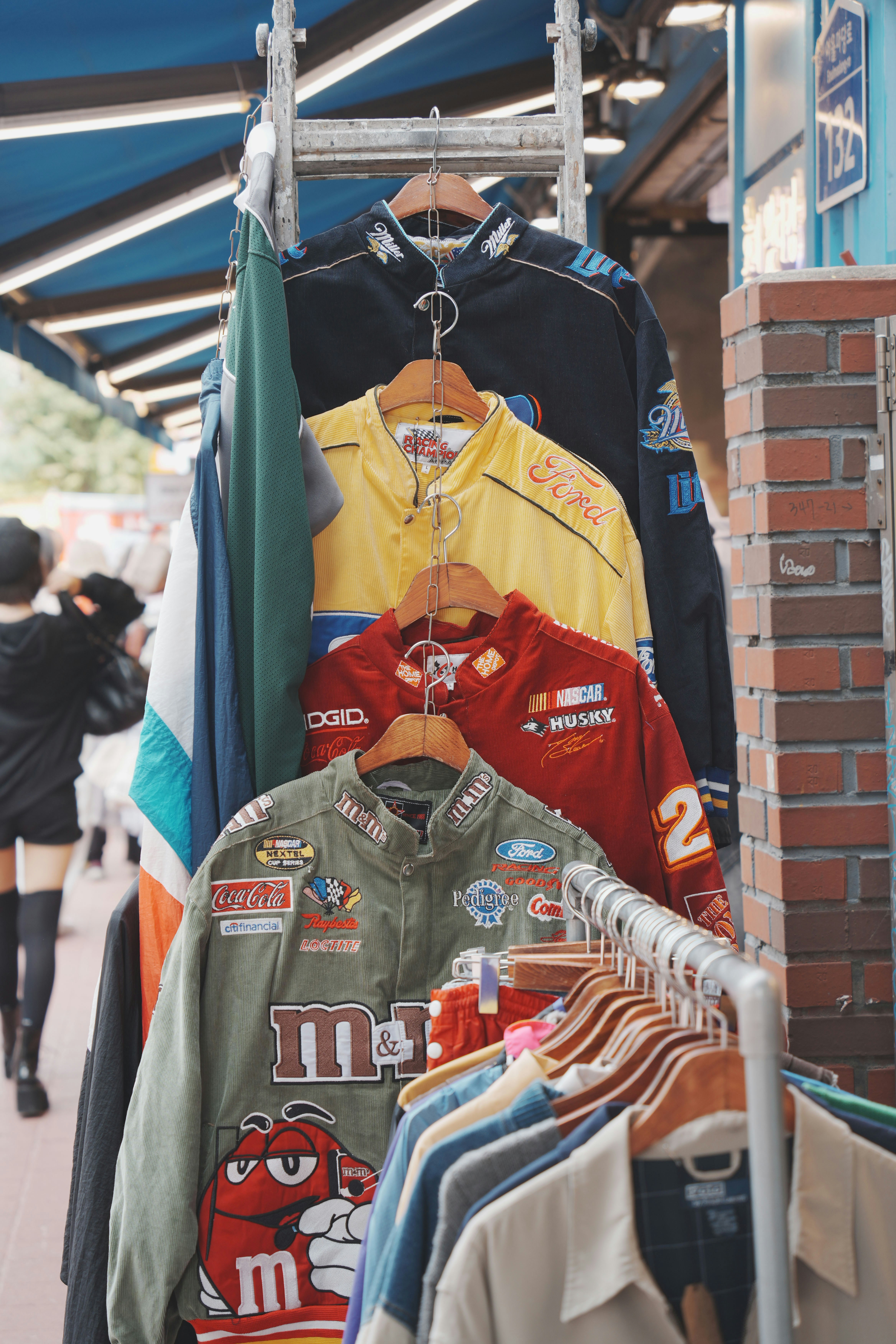 Race car jackets hang in a vintage clothing shop.