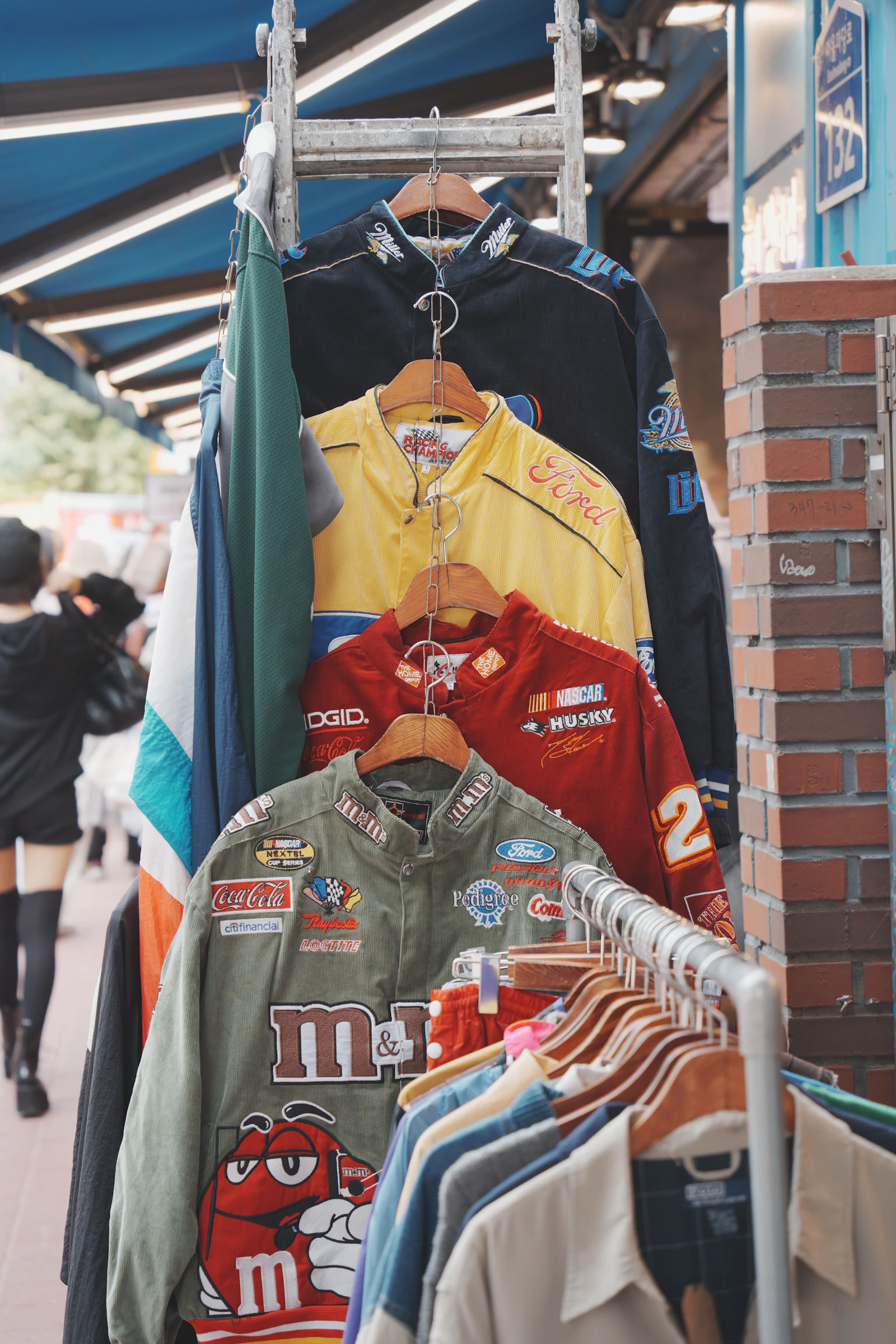 Racing jackets hanging on a rack inside a small vintage clothing shop