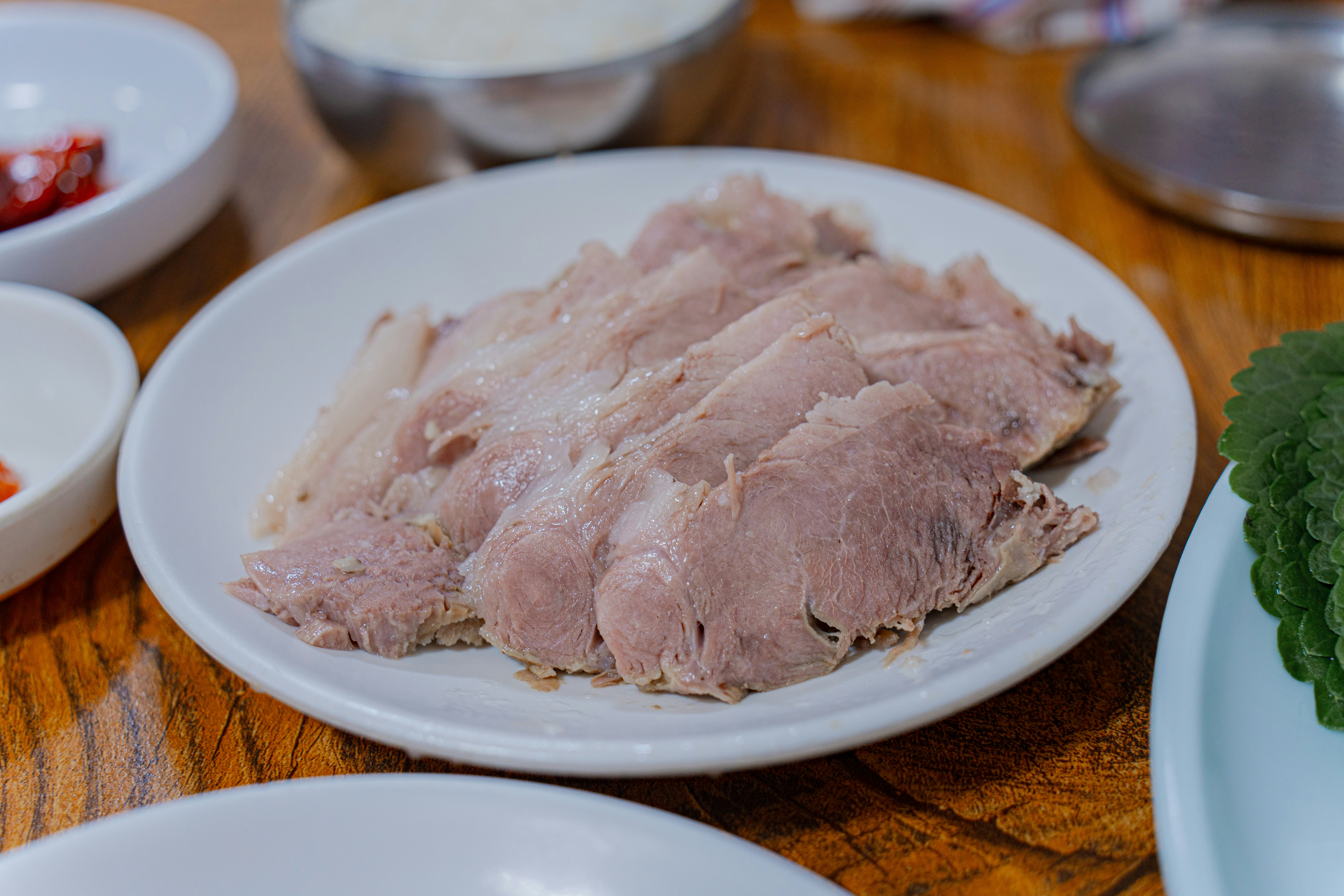 Close-up of sliced brisket, ribs, and pulled pork on a platter - BBQ catering menu