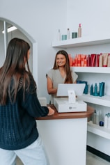 A customer pays at a hair salon's front desk.