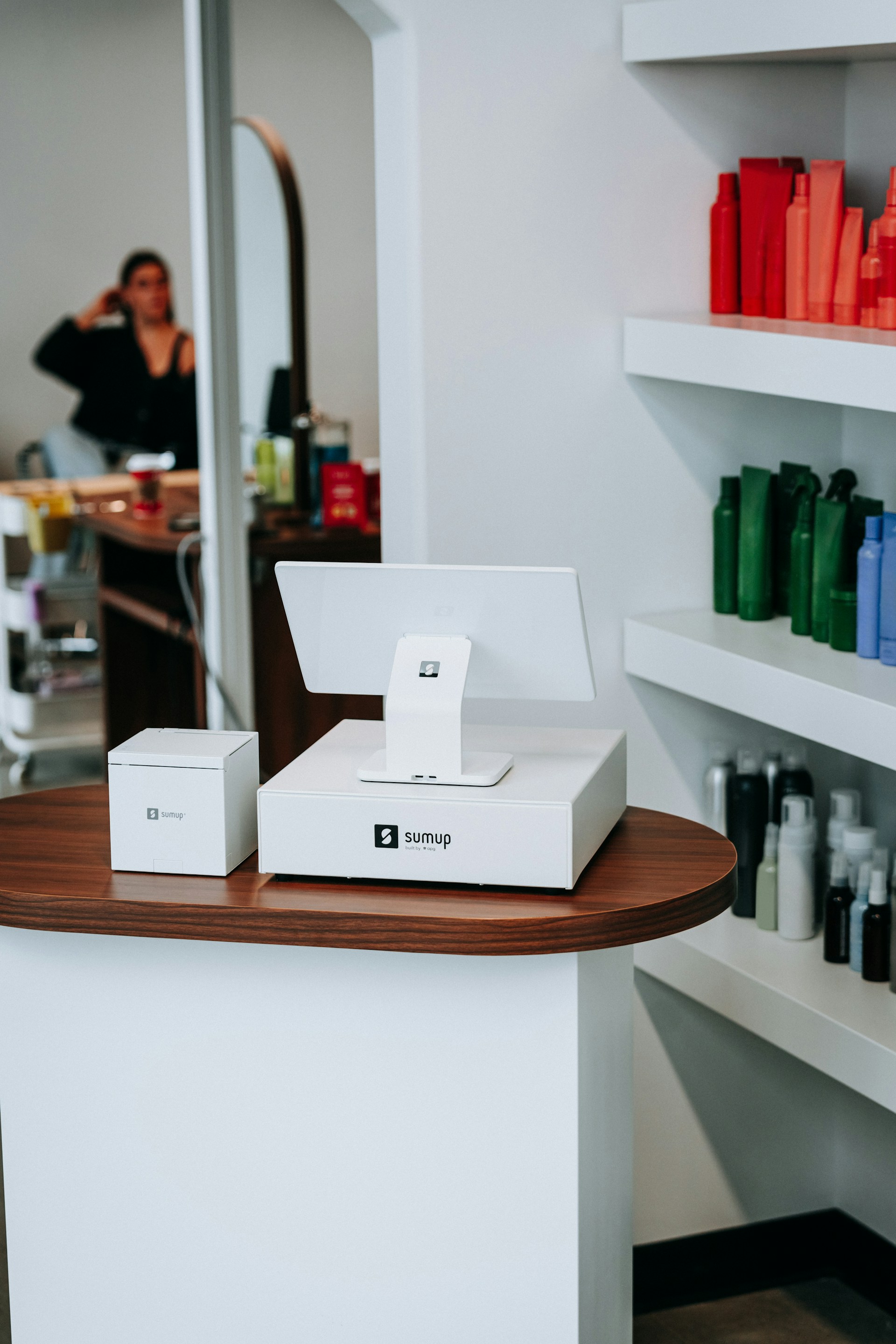 Salon's cash register sits on a wooden table.