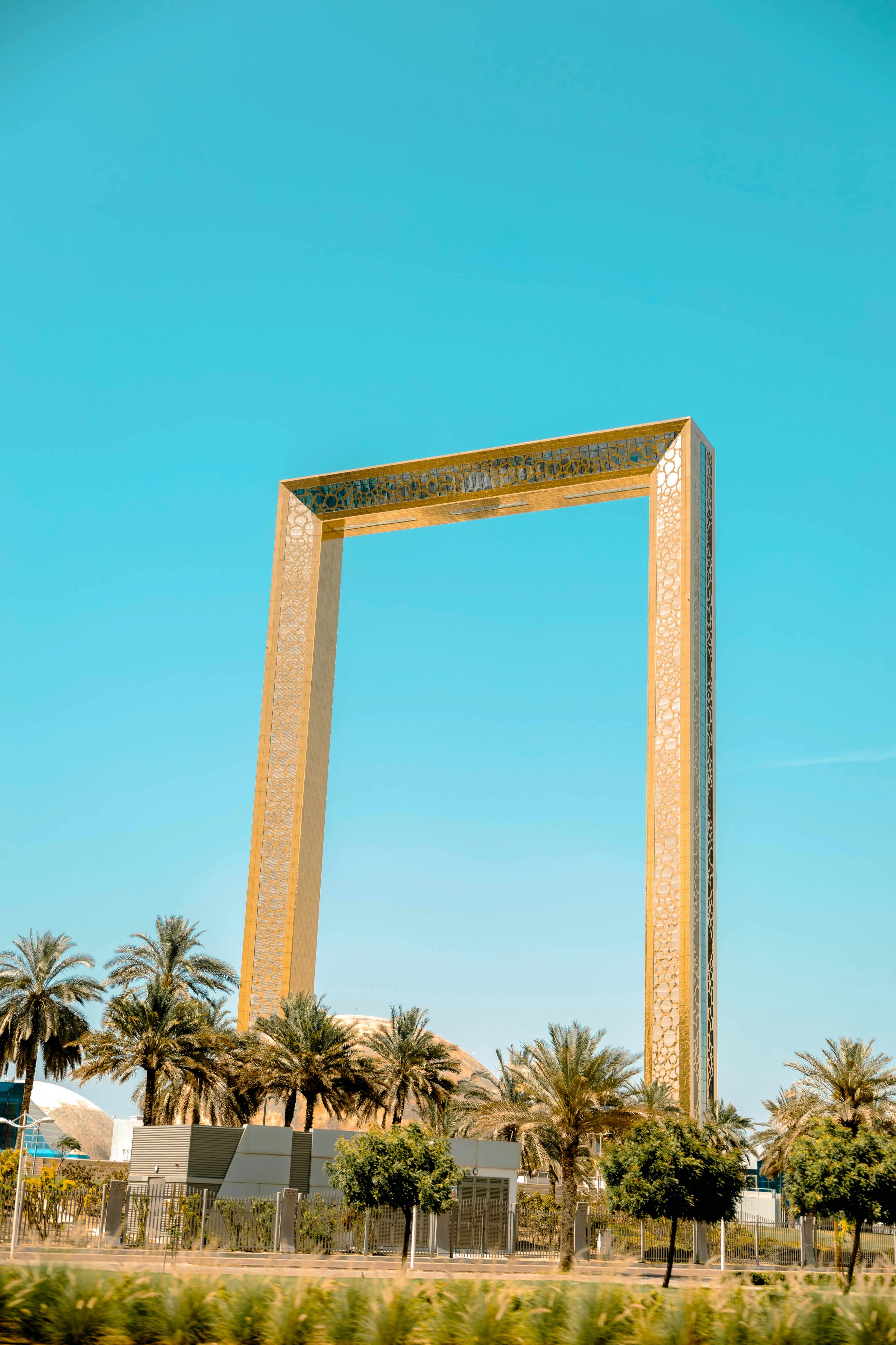 The dubai frame stands tall against a blue sky.