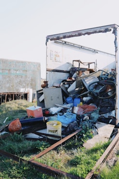 An overfilled trailer contains various types of trash.