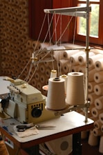A sewing machine with spools of thread.