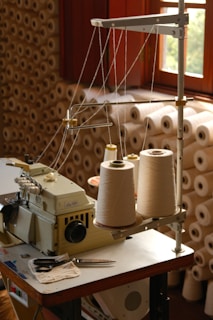 A sewing machine with spools of thread.