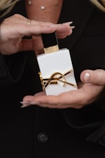 Woman's hands holding a luxurious perfume bottle.
