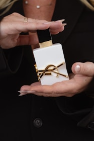 Woman's hands holding a luxurious perfume bottle.